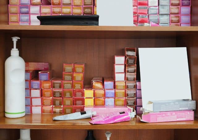 Box dye vs salon dye - shelf of salon hair dyes and tubes in hair salon
