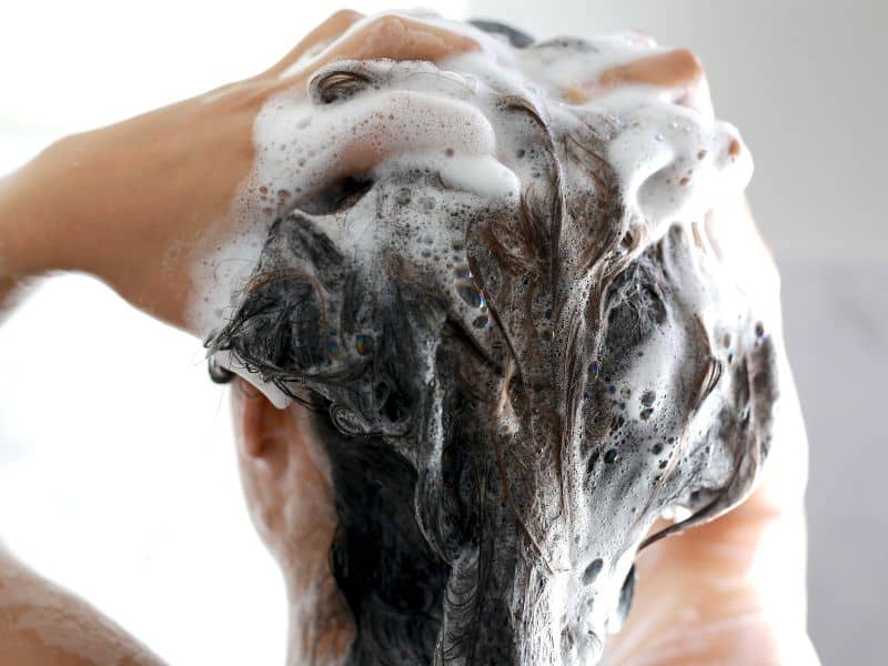 lady using clarifying shampoo to remove semi permanent hair dye