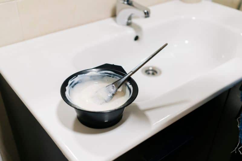 bleach bath mixture being prepared in a bowl at home bathroom counter