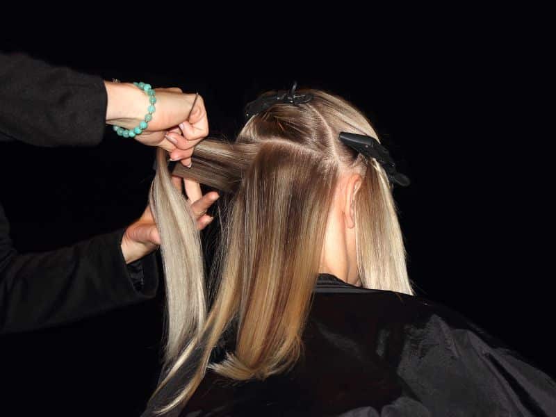what does hair toner do to highlights? blonde hair being sectioned by stylist