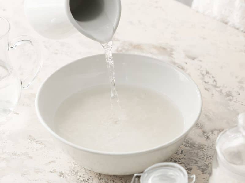 Can You Use Rice Water on Color-Treated Hair - water being poured into rice bowl to soak
