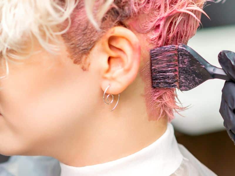 pink hair dye being applied to a womans hair