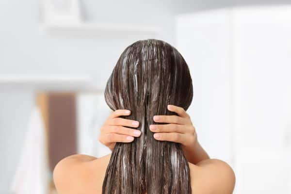 Weekly Hair Care Routine - woman with hair conditioner in